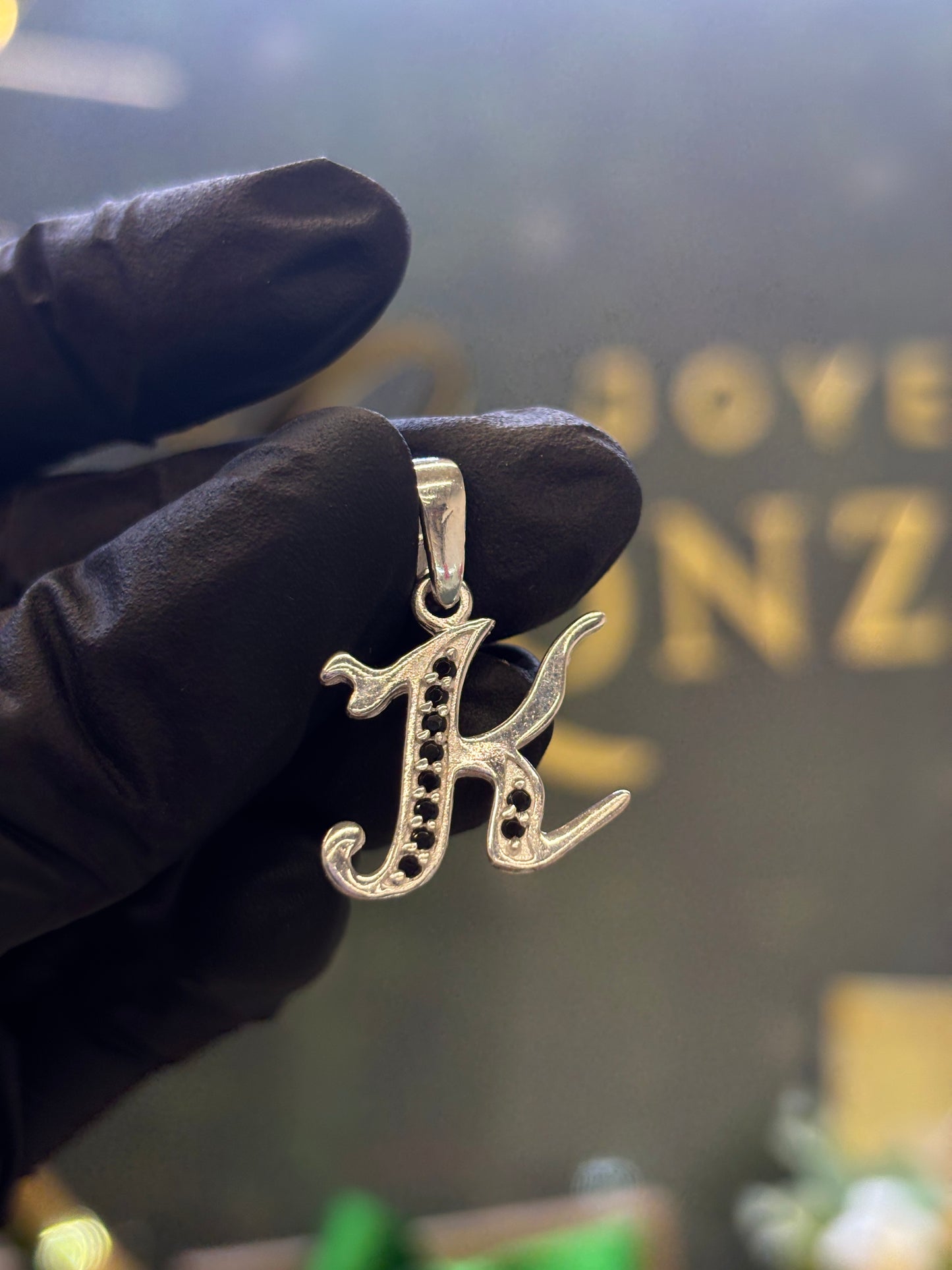 Inicial K cursiva plata