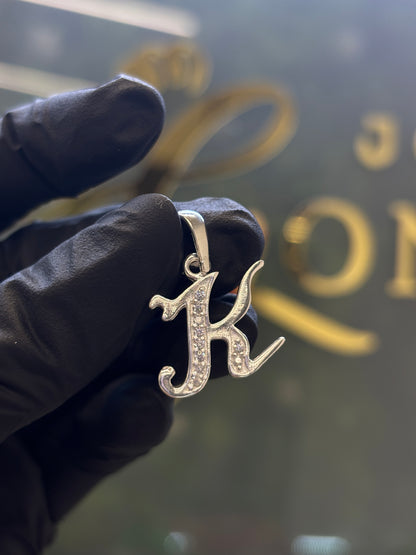 Inicial K cursiva plata