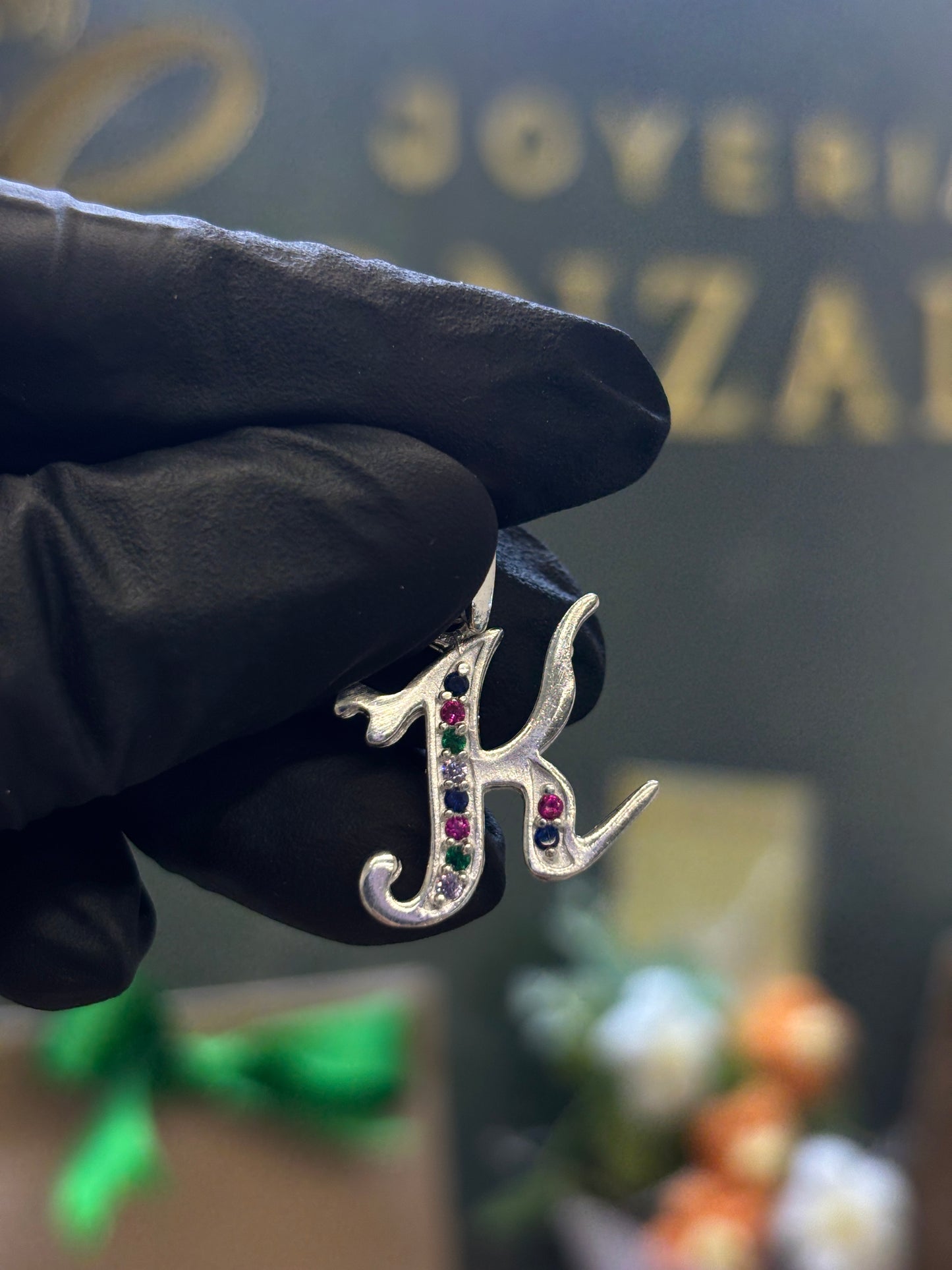 Inicial K cursiva plata