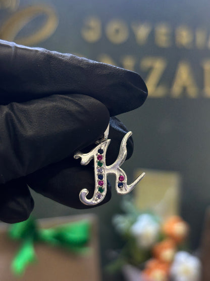 Inicial K cursiva plata