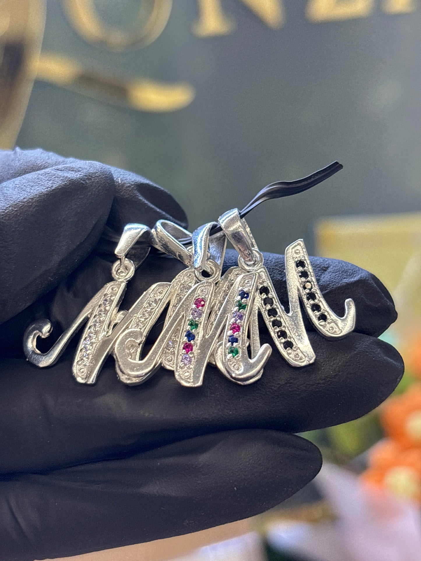 Inicial M cursiva plata