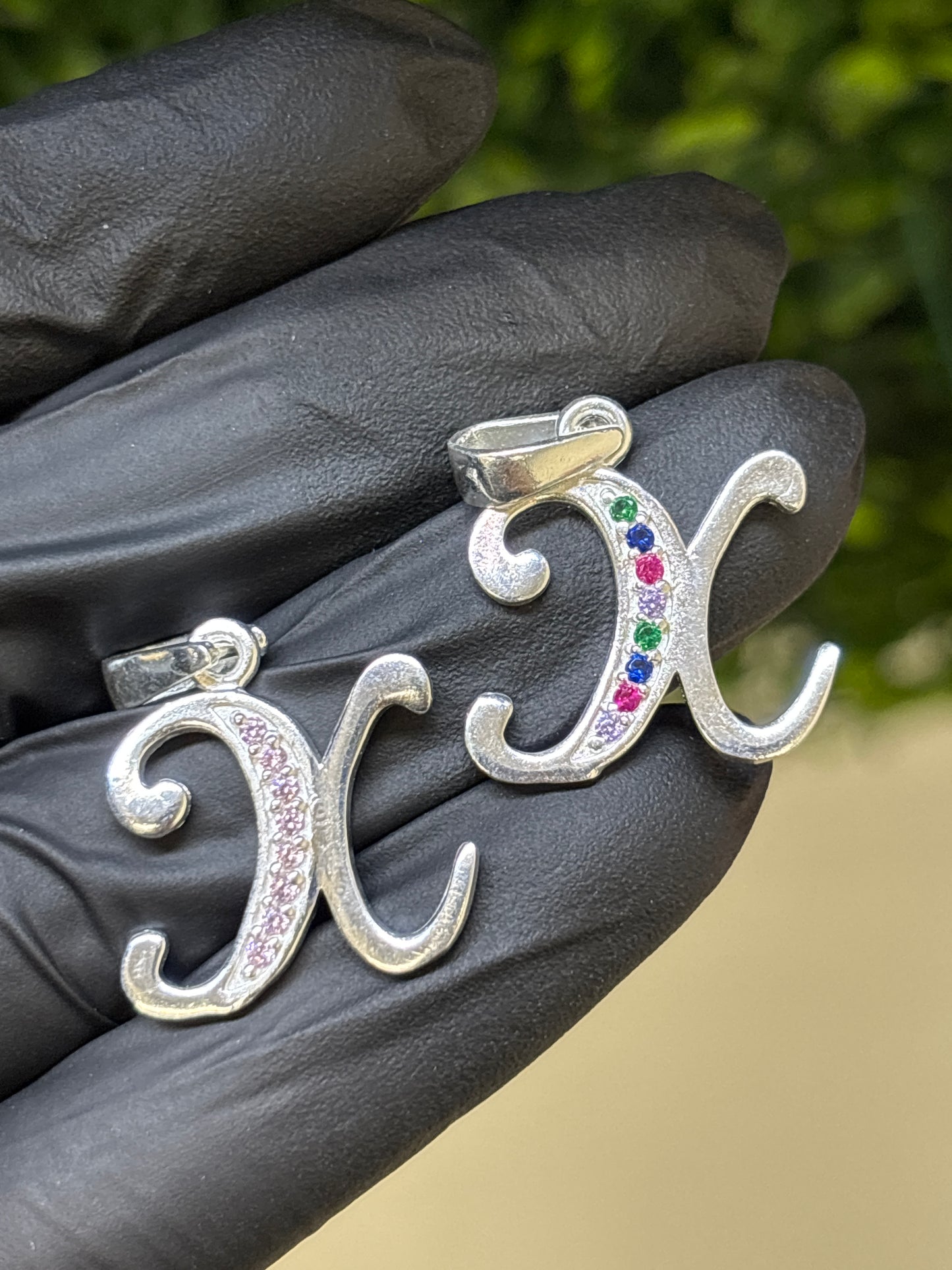 Inicial X cursiva plata