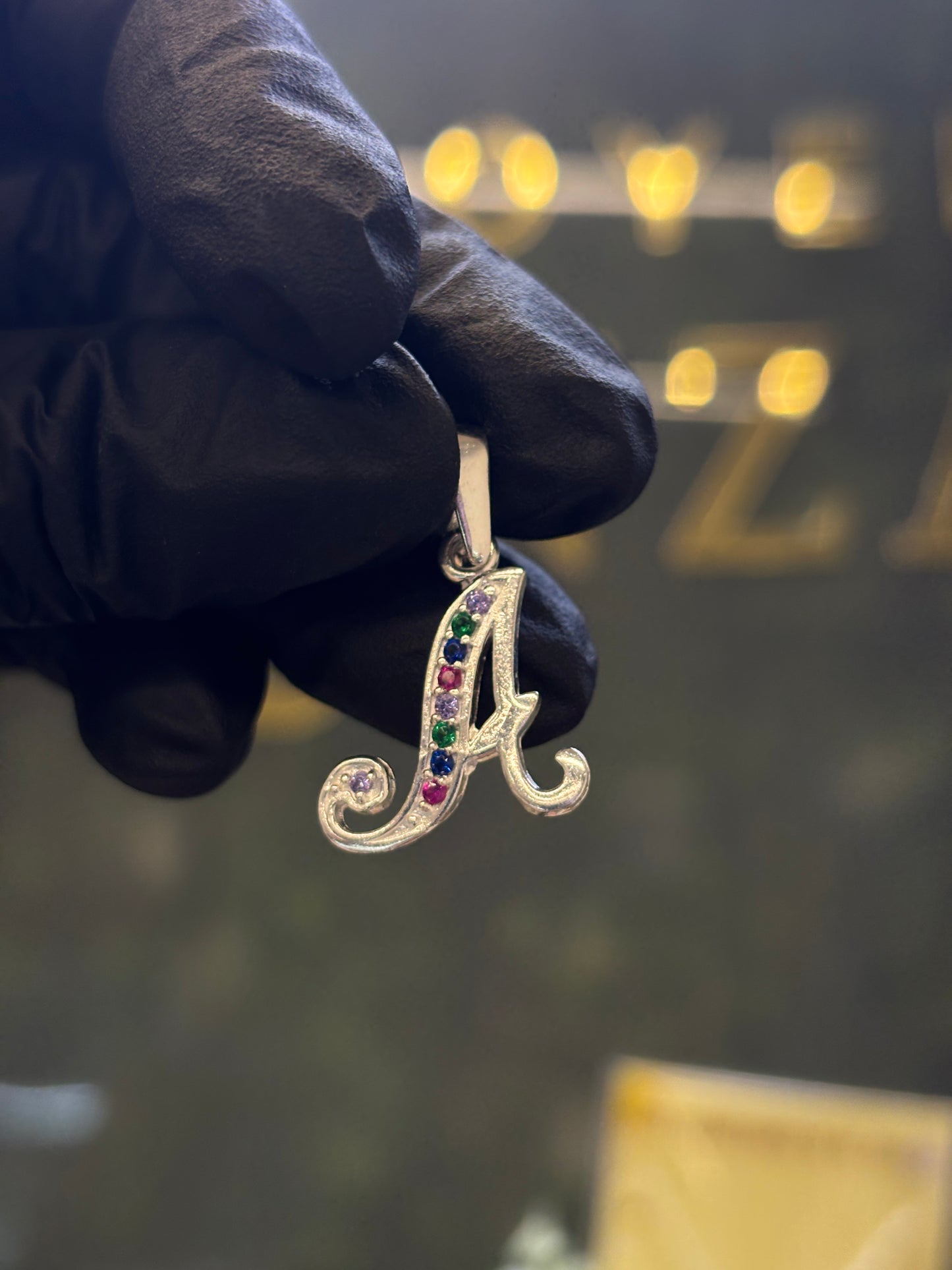Inicial A cursiva plata